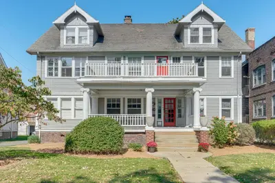 a large white house with a red door at Walk to Coventry Village Charming Top-Floor Unit! in Cleveland Heights
