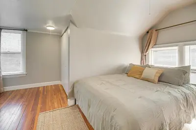 a bedroom with a bed and two windows at Walk to Coventry Village Charming Top-Floor Unit! in Cleveland Heights
