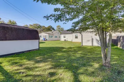 a tree in a yard next to a house at Easy I-80 Access! Newly Updated McDonald Home