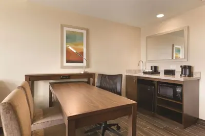 a room with a table and a kitchen with a counter at Embassy Suites by Hilton Akron Canton Airport in North Canton