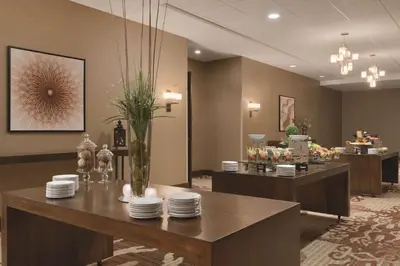 a restaurant with a table with plates on it at Embassy Suites by Hilton Akron Canton Airport in North Canton