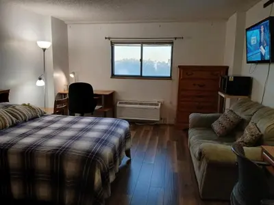 a bedroom with a bed and a couch and a window at Right by OSU Stadium and Schottenstein Ctr - Walk to your game or concert in Columbus