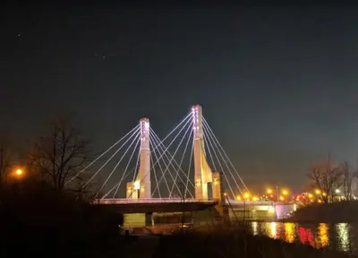 a lit up bridge over the water at night at Right by OSU Stadium and Schottenstein Ctr - Walk to your game or concert in Columbus