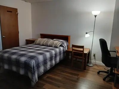 a bedroom with a bed and a desk and a lamp at Right by OSU Stadium and Schottenstein Ctr - Walk to your game or concert in Columbus