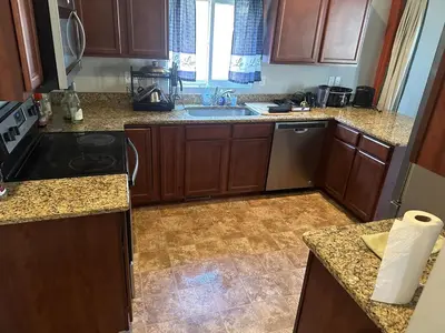 a kitchen with wooden cabinets and a sink at Nice Basement room in the house in Medina