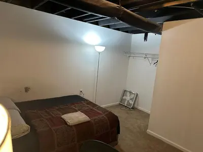 a bedroom with a bed and a lamp in a room at Nice Basement room in the house in Medina