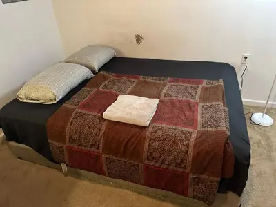 a bed with two pillows on it in a room at Nice Basement room in the house in Medina