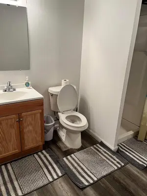 a bathroom with a white toilet and a sink at Nice Basement room in the house in Medina