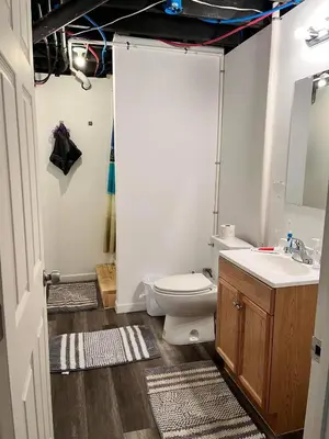 a bathroom with a toilet and a sink at Nice Basement room in the house in Medina