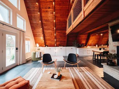 a large living room with wooden ceilings and chairs at Cozy A-Frame Getaway Minutes from Nelson Ledges