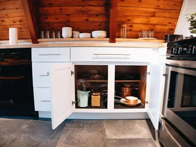 a kitchen with white cabinets and a stove at Cozy A-Frame Getaway Minutes from Nelson Ledges