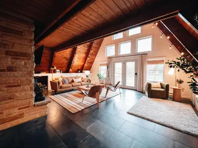 a living room filled with furniture and a brick wall at Cozy A-Frame Getaway Minutes from Nelson Ledges