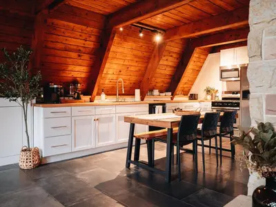 a kitchen with white cabinets and a wooden ceiling at Cozy A-Frame Getaway Minutes from Nelson Ledges