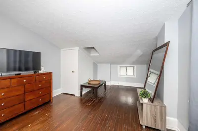 a living room with a dresser and a flat screen tv at Queen City Suites 2 - For 4 in Cincinnati