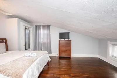 a bedroom with a bed and a dresser with a tv at Queen City Suites 2 - For 4 in Cincinnati