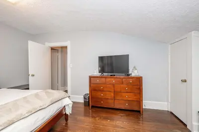 a bedroom with a bed and a dresser with a tv on it at Queen City Suites - For 7 in Cincinnati