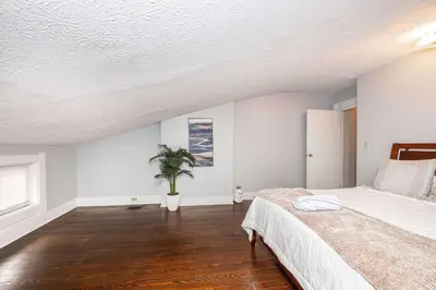 a bedroom with a bed and a potted plant at Queen City Suites - For 7 in Cincinnati