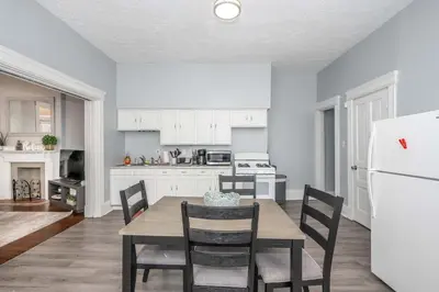 a kitchen with a table and chairs and a white refrigerator at Queen City Suites 1 - For 3 in Cincinnati