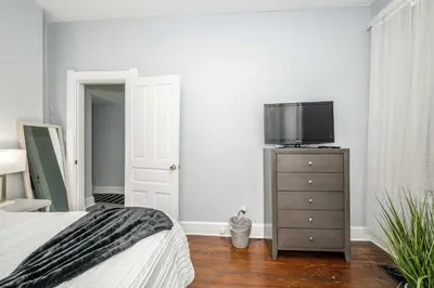 a bedroom with a bed and a tv on a dresser at Queen City Suites 1 - For 3 in Cincinnati