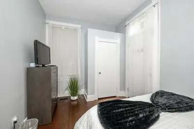 a bedroom with a bed and a television on a dresser at Queen City Suites 1 - For 3 in Cincinnati