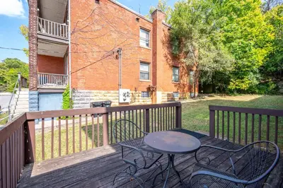 a patio with a table and chairs on a deck at Queen City Suites 1 - For 3 in Cincinnati