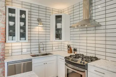 a white kitchen with a stove and a sink at 7 Mi to Dtwn and Lake Erie Sleek Cleveland Apt! in Cleveland
