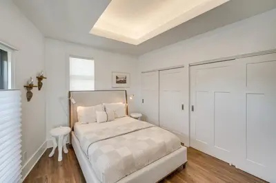 a white bedroom with a bed and a white closet at 7 Mi to Dtwn and Lake Erie Sleek Cleveland Apt! in Cleveland