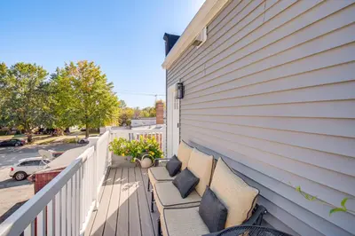 a porch with benches on the side of a house at 7 Mi to Dtwn and Lake Erie Sleek Cleveland Apt! in Cleveland