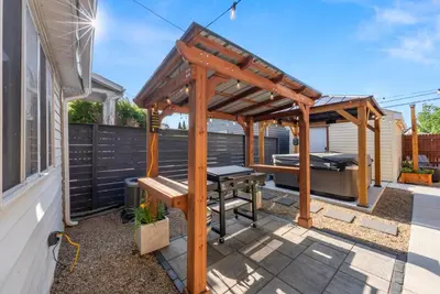 a wooden pergola with a picnic table on a patio at Wellness Retreat - Hot Tub Fire Pit Outdoor TV in Columbus
