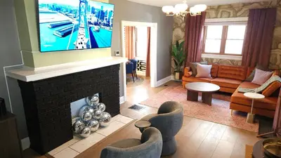 a living room with a tv on top of a fireplace at The Funky Fun Haus - Pickleball, Hot Tub, Arcade in Columbus