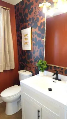 a bathroom with a toilet and a sink and a mirror at The Funky Fun Haus - Pickleball, Hot Tub, Arcade in Columbus