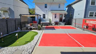 a backyard with a basketball court and a basketball hoop at The Funky Fun Haus - Pickleball, Hot Tub, Arcade in Columbus