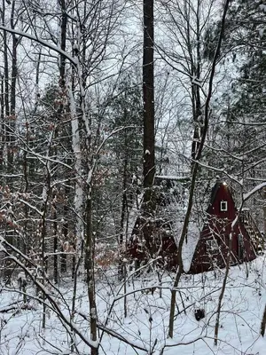 a small red house in the woods in the snow at Waterfront A Frame with Dock Canoe Kayaks Family in Rockbridge