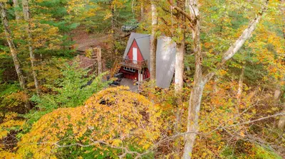 an aerial view of a small red cabin in the woods at Waterfront A Frame with Dock Canoe Kayaks Family in Rockbridge