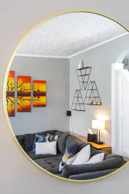 a living room with a couch in front of a mirror at Modern 3BR w Yard Garage in Columbus