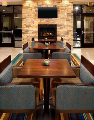 a restaurant with tables and chairs and a fireplace at Hawthorn Suites by Wyndham Bridgeport in Bridgeport