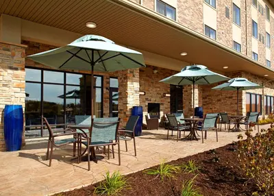 a patio with tables and chairs and umbrellas at Hawthorn Suites by Wyndham Bridgeport in Bridgeport