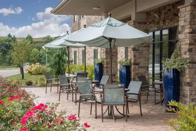 a table and chairs with an umbrella on a patio at Hawthorn Suites by Wyndham Bridgeport in Bridgeport