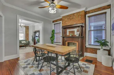 a dining room with a table and chairs and a fireplace at Charming Historic Getaway in the Heart of Columbus in Columbus