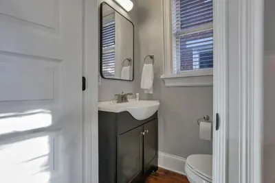a bathroom with a sink and a mirror and a toilet at Charming Historic Getaway in the Heart of Columbus in Columbus