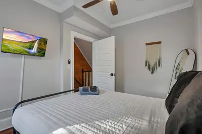 a white bedroom with a bed and a ceiling fan at Charming Historic Getaway in the Heart of Columbus in Columbus