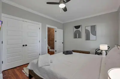 a white bedroom with a bed and a ceiling fan at Charming Historic Getaway in the Heart of Columbus in Columbus