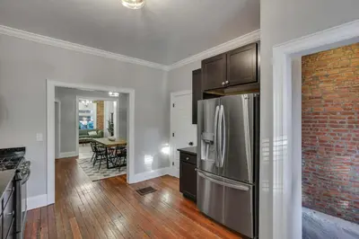 a kitchen with a stainless steel refrigerator and a dining room at Charming Historic Getaway in the Heart of Columbus in Columbus