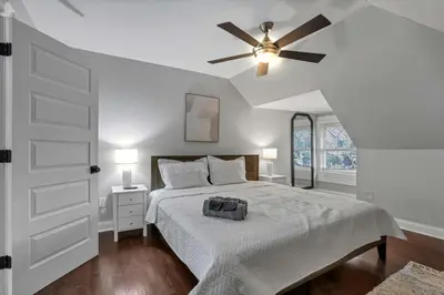 a bedroom with a bed and a ceiling fan at Charming Historic Getaway in the Heart of Columbus in Columbus