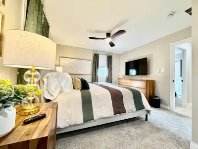 a bedroom with a bed with a ceiling fan and a table at Brand new remodeled home in Monroe in Monroe