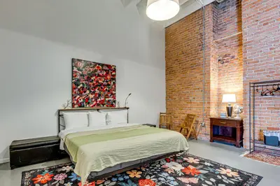 a bedroom with a bed and a brick wall at Walk to Huntington Center 5,000-Sq-Ft Dtwn Apt in Toledo