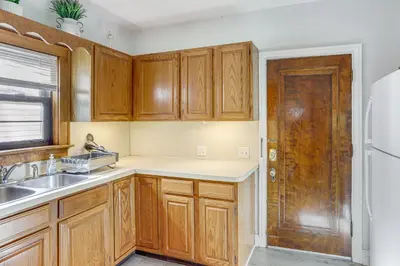 a kitchen with wooden cabinets and a wooden door at Striking Tudor Revival in Five Points District! in Toledo