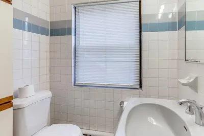 a bathroom with a toilet and a sink at Striking Tudor Revival in Five Points District! in Toledo