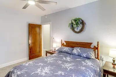 a bedroom with a bed and two lamps and a ceiling fan at Striking Tudor Revival in Five Points District! in Toledo