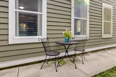 two chairs and a table with flowers on a porch at Walk to UC and Hospitals! Cincy Home with Patio in Cincinnati
